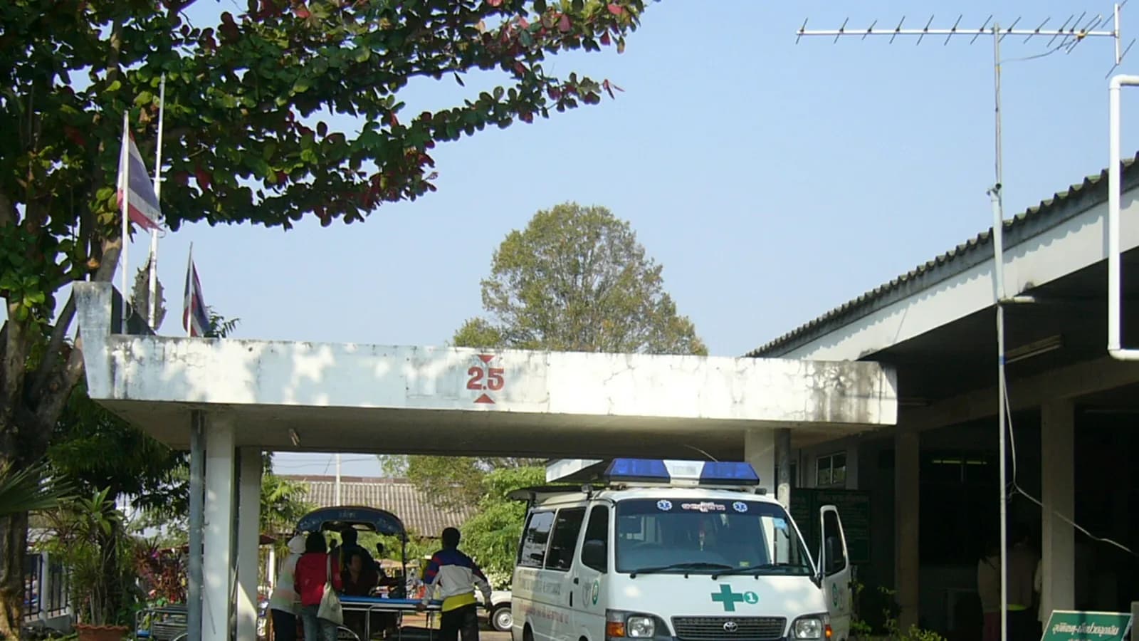 The covered emergency entrance of a hospital with a vehicle pulled up under the canopy