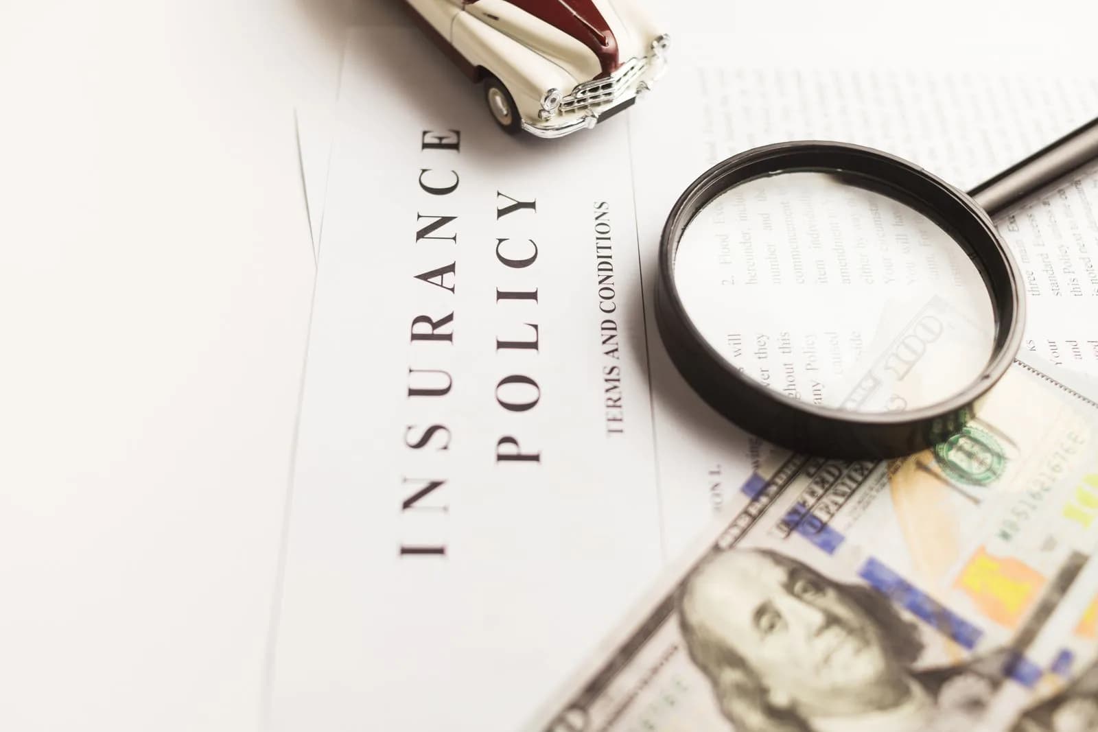An insurance policy document with a magnifying glass and a toy car