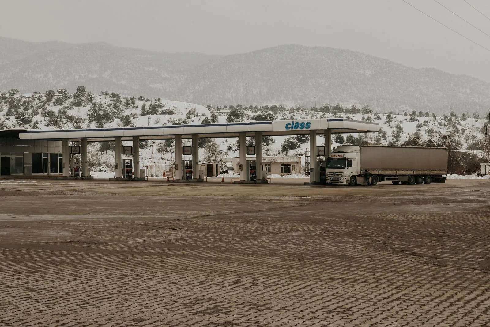 A commercial truck stopped at a roadside weigh station for inspection