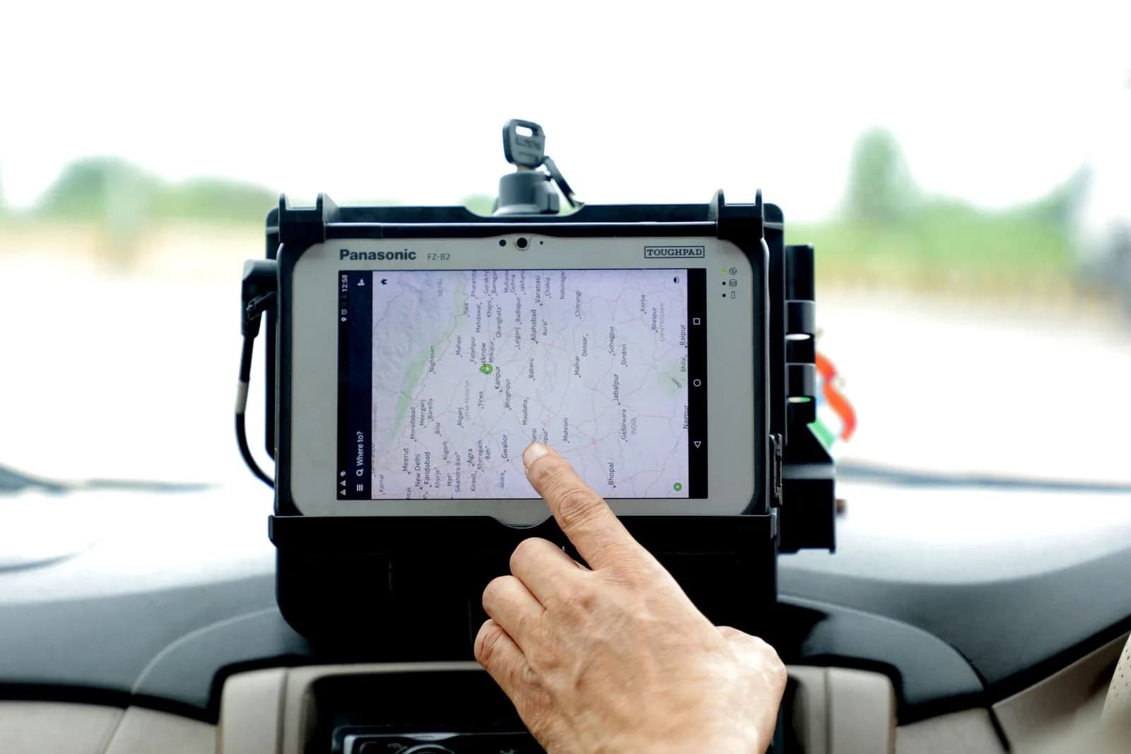 A telematics device installed under a commercial vehicle dashboard with a wiring harness connected