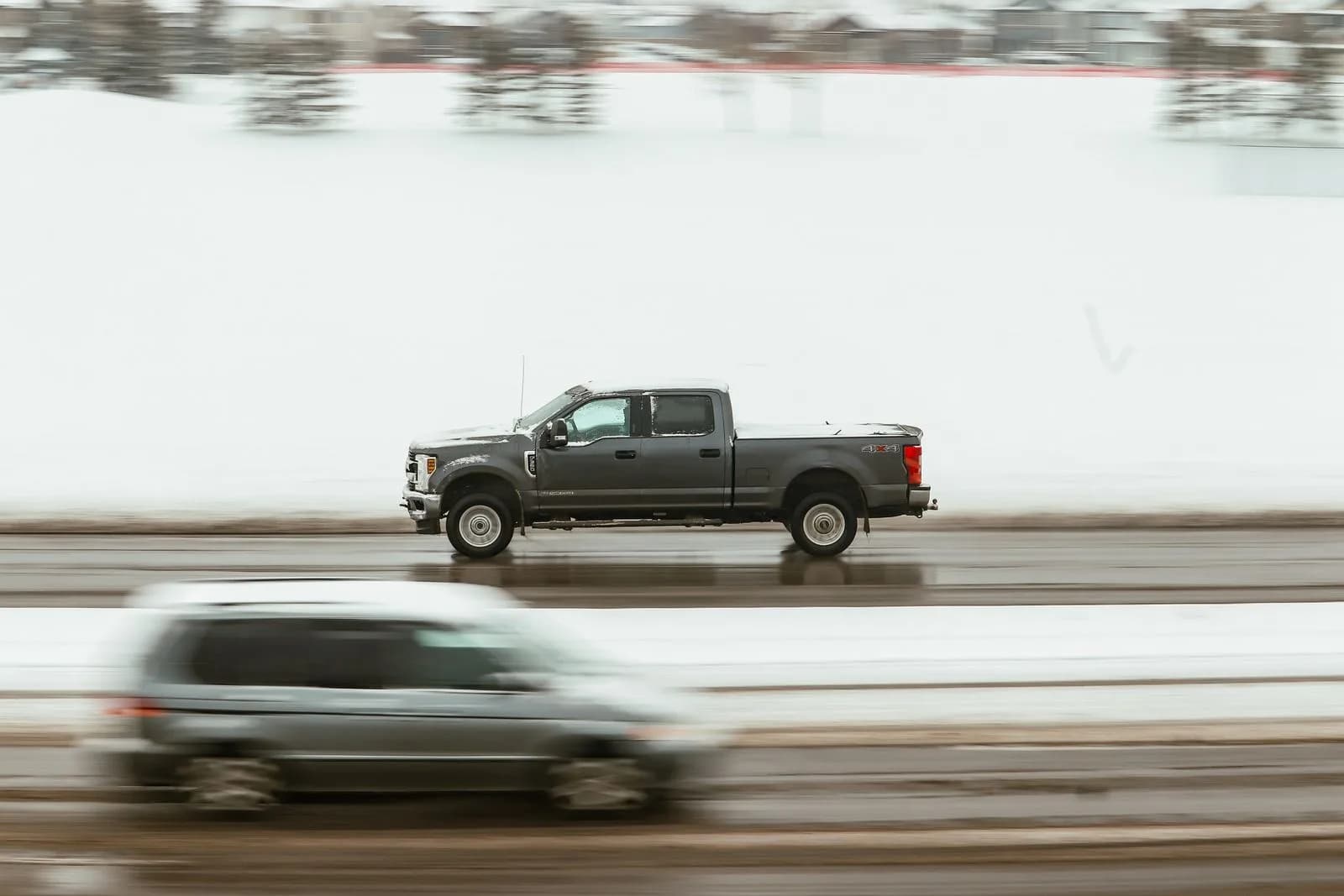 A pickup truck driving on a snowy highway in Calgary, Canada