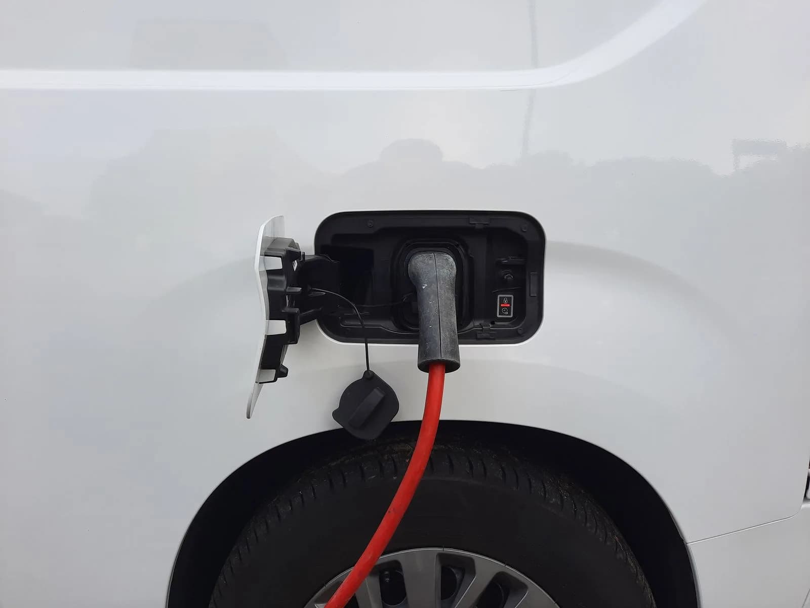 Close-up of an electric vehicle charging port with a connected charging cable