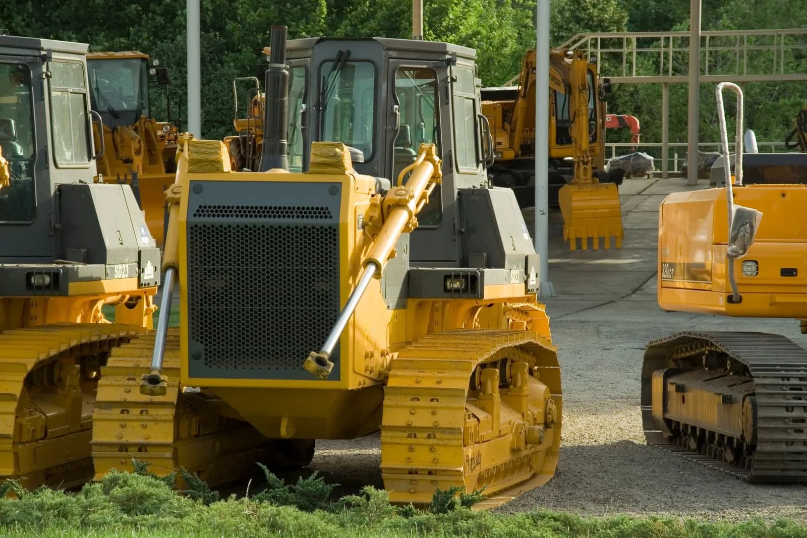 Multiple pieces of heavy construction equipment parked in an outdoor rental yard