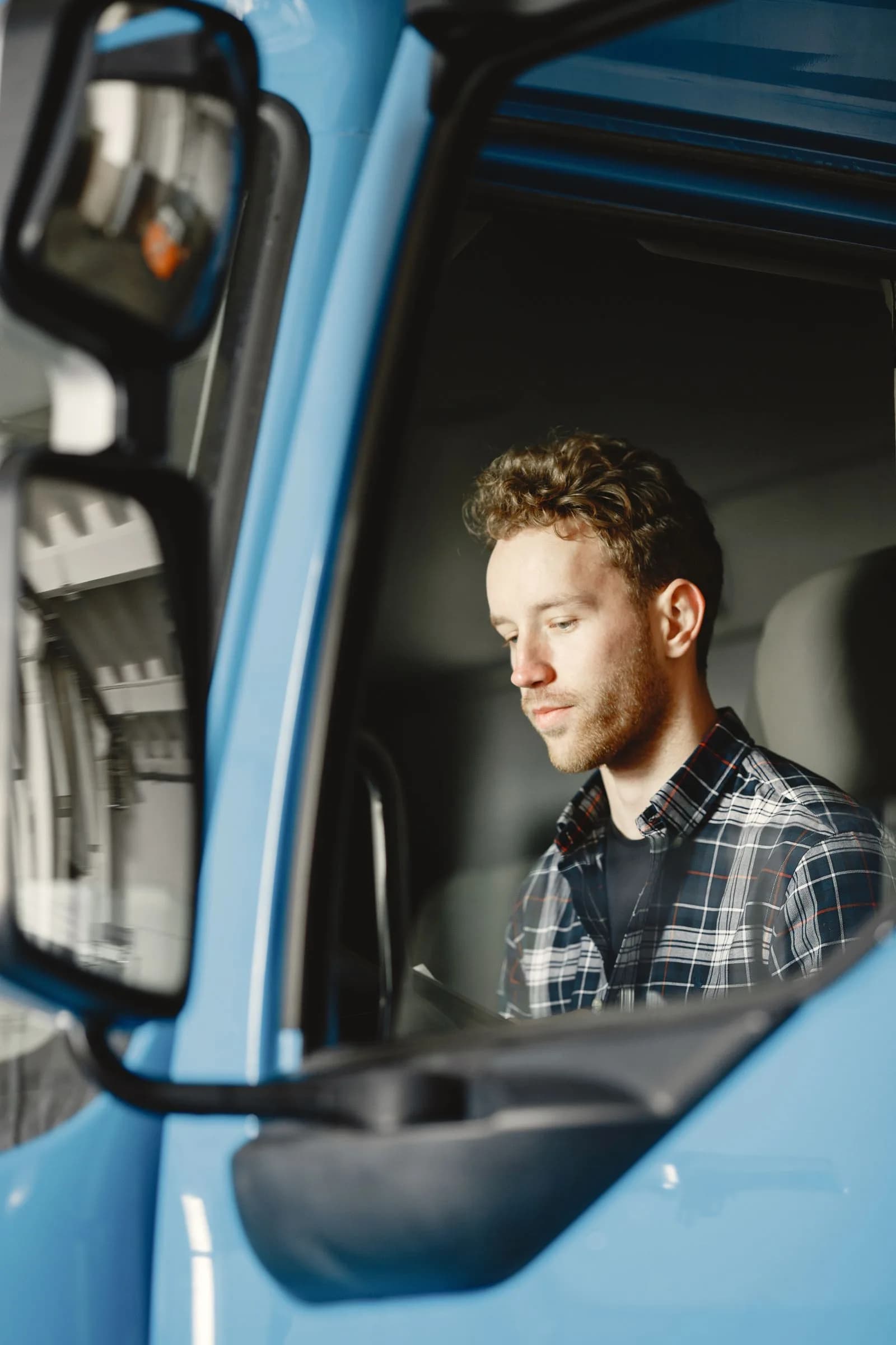 A truck driver seated in the cab of a commercial vehicle