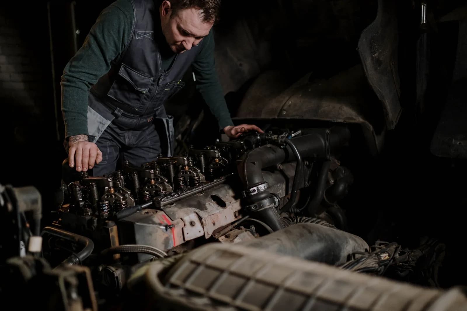 Un mécanicien de parc consultant le diagnostic moteur d'un camion commercial sur un portable dans une baie de service