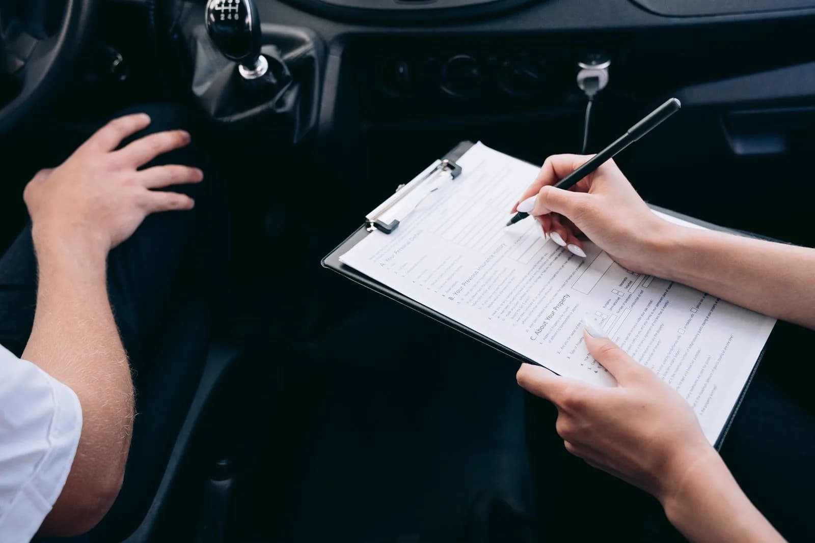 A person reviewing a form on a clipboard inside a commercial vehicle