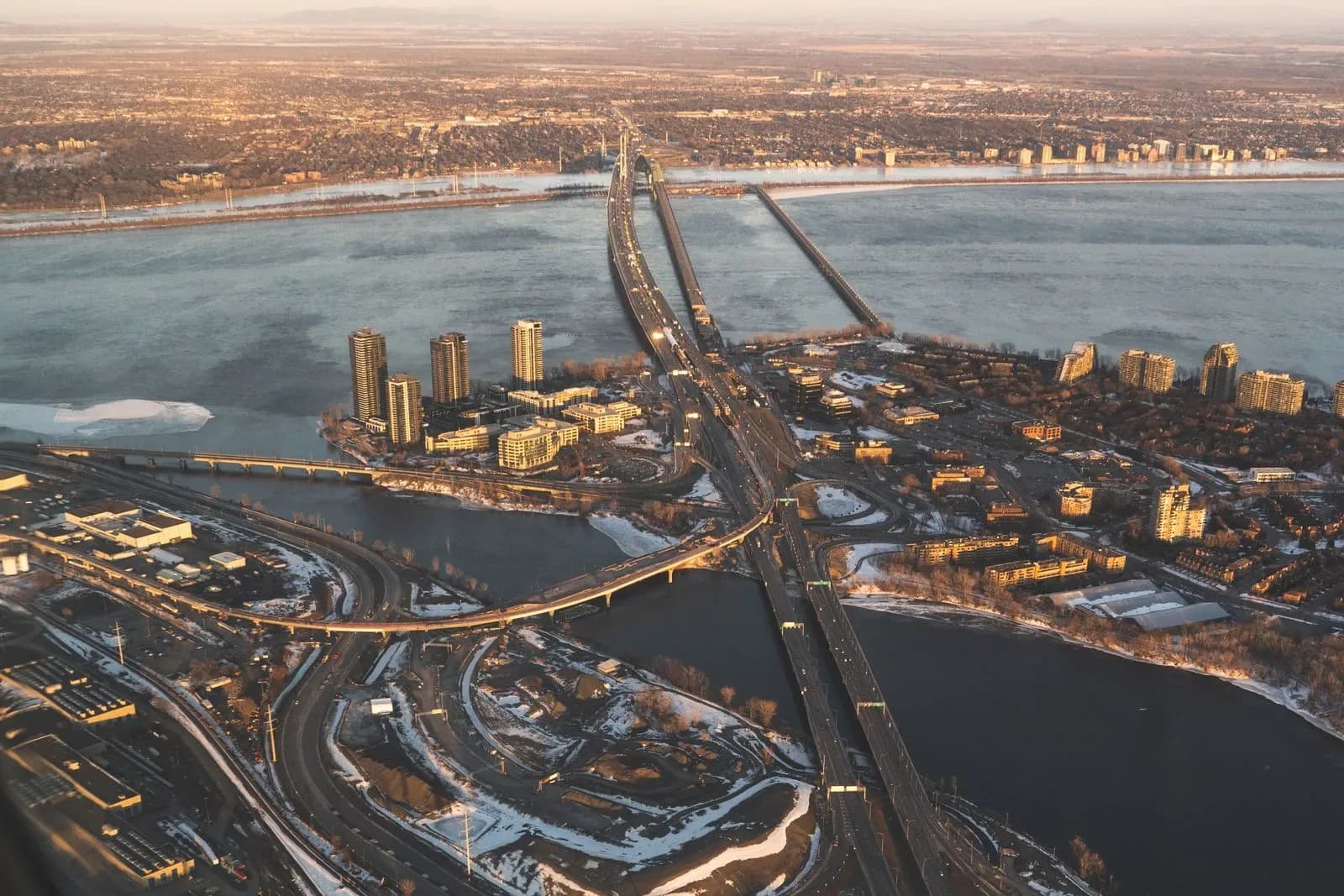 An aerial view of Montreal at sunrise, with the bridges and highways a fleet runs on