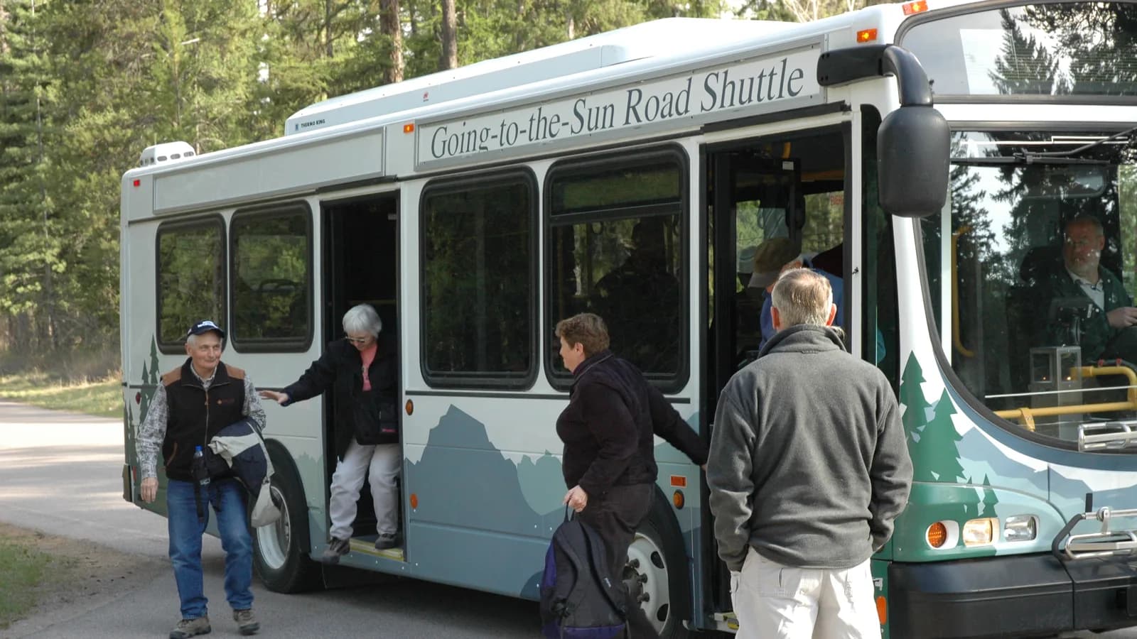 Passengers boarding a shuttle bus at a stop