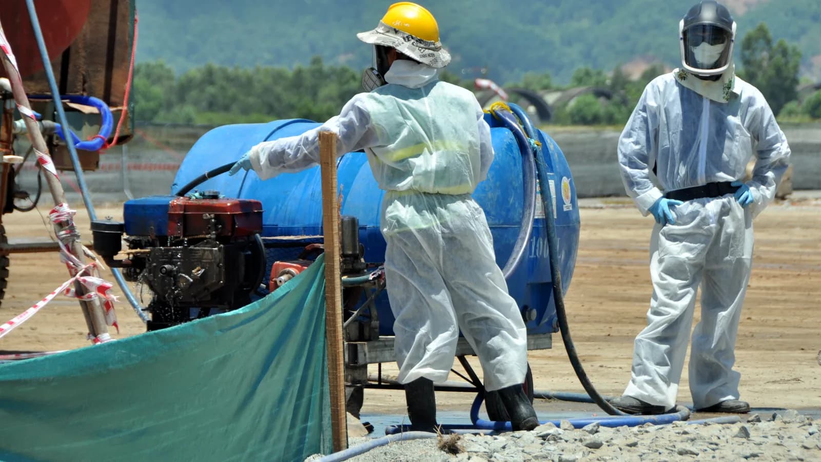 Workers in protective suits at an environmental cleanup site