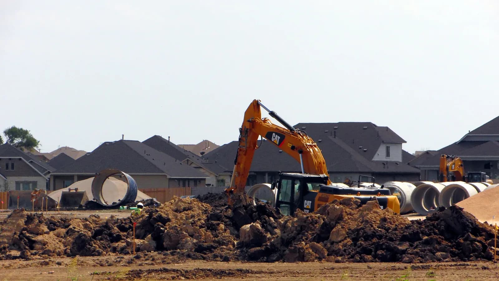 An excavator grading a lot in a new housing development