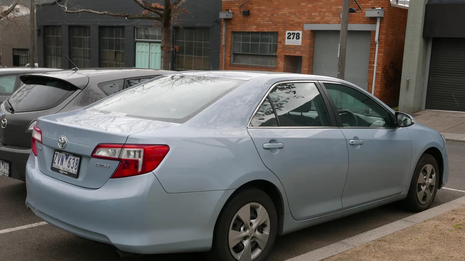 A grey sedan parked in a government office parking lot