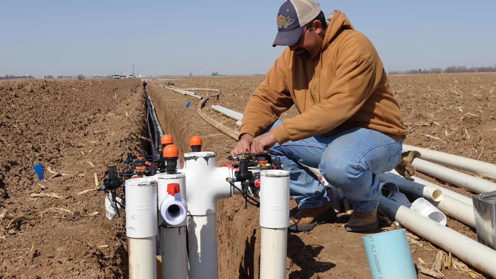 A worker assembling irrigation valves in a field