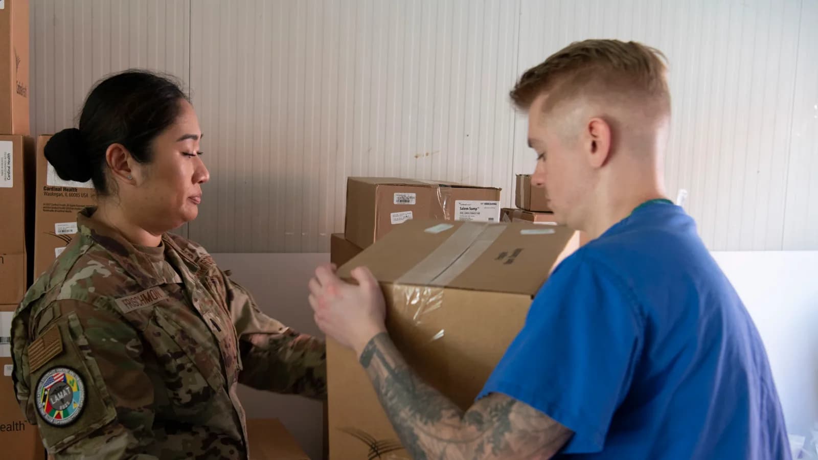 A nurse receiving a delivery of boxed medical supplies
