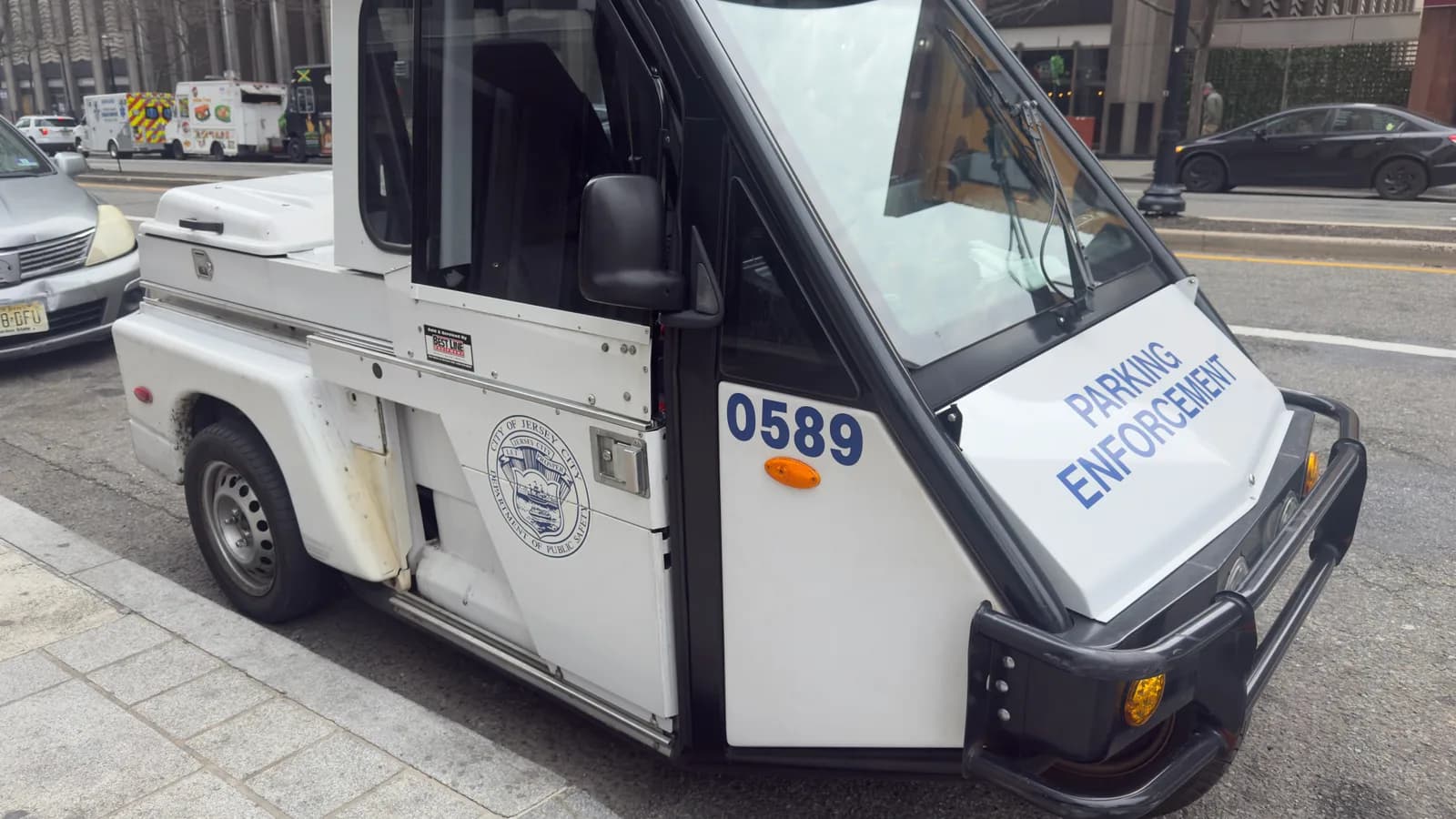 A compact parking enforcement vehicle on a city street