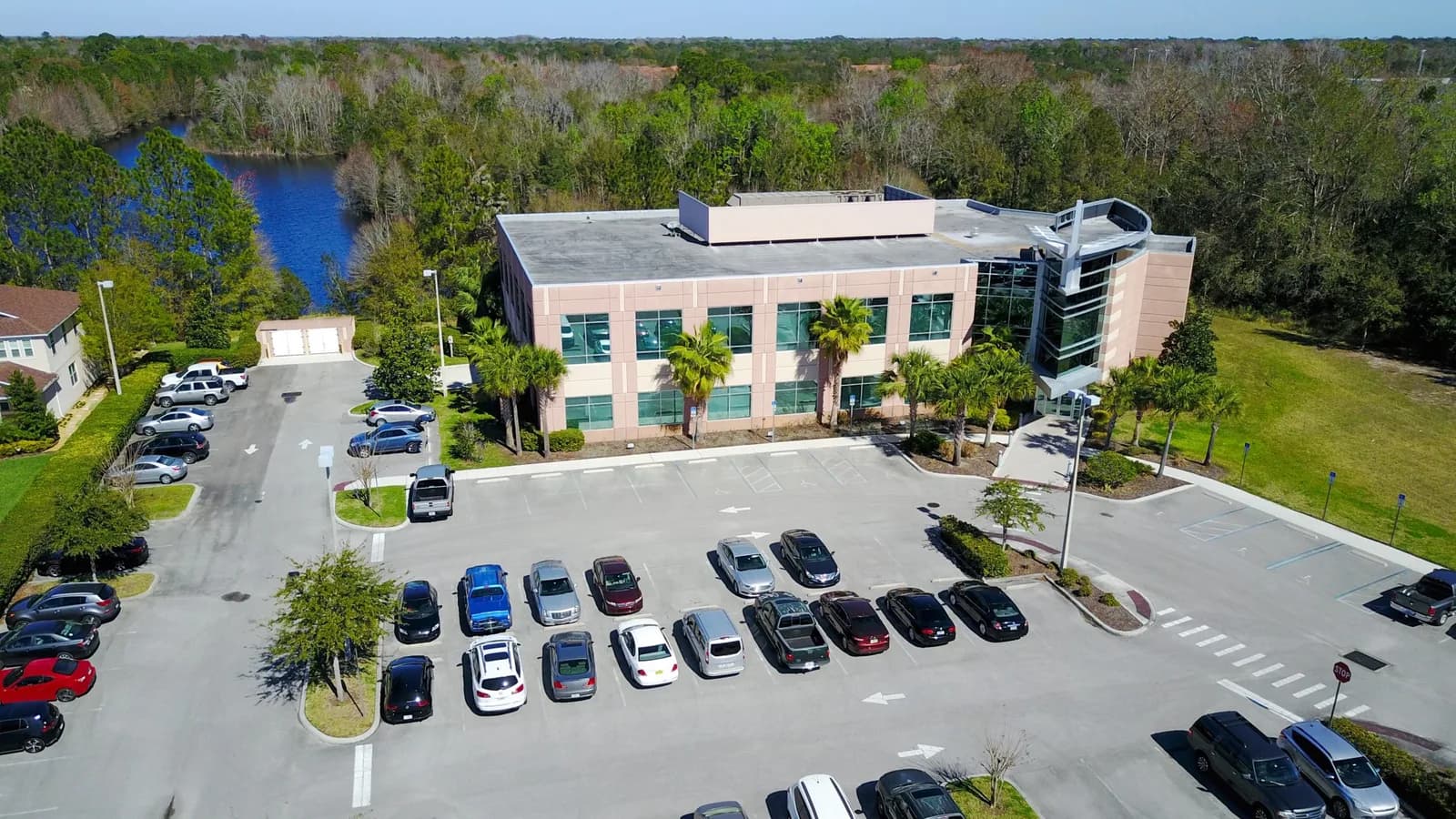 An aerial view of an office building with company cars in its parking lot