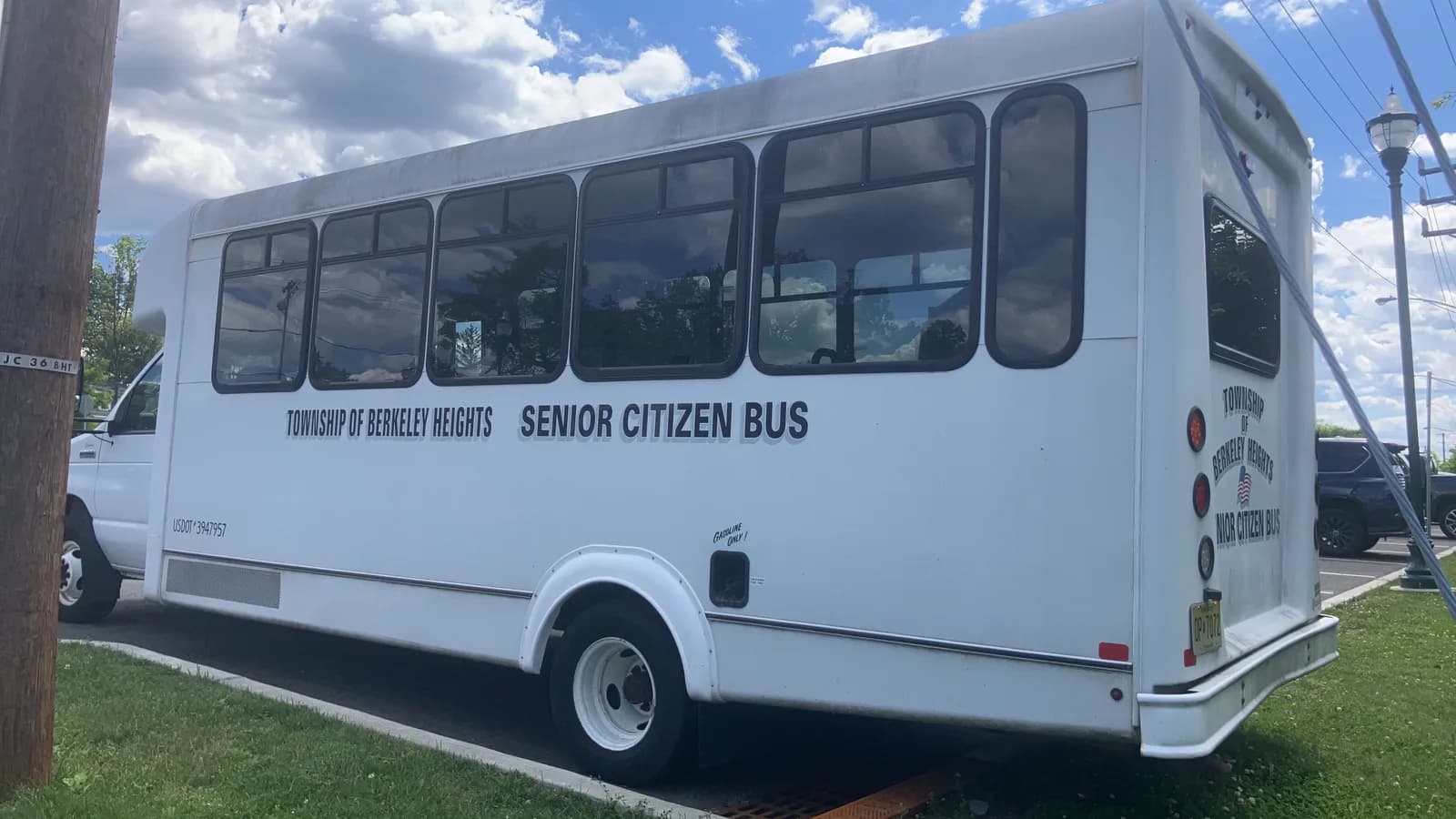 A white senior citizen shuttle bus parked outside