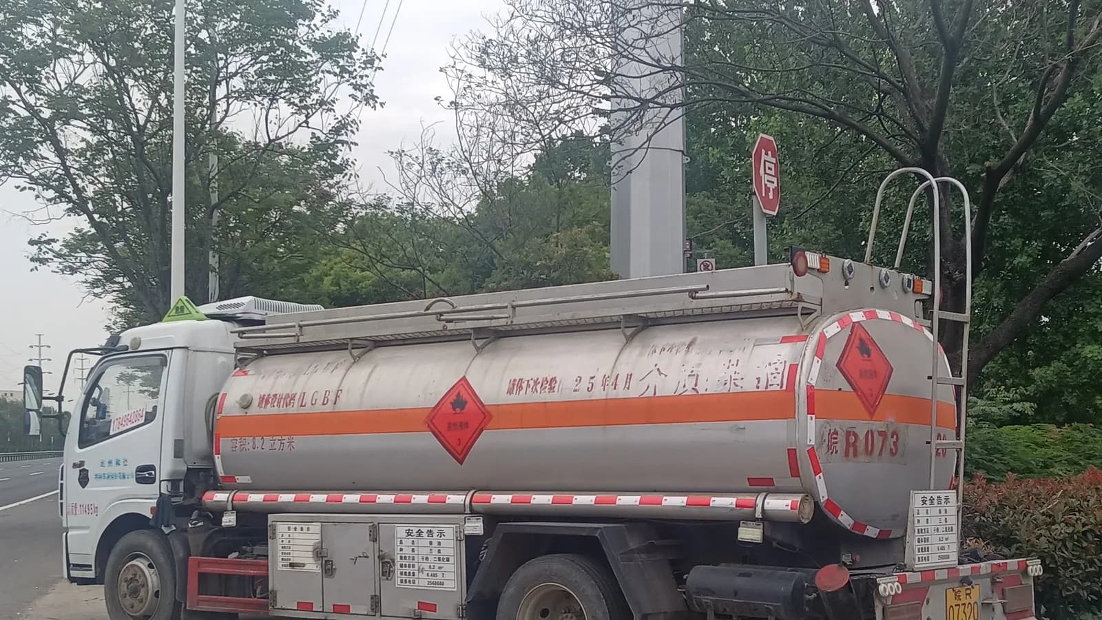 A fuel tanker truck with an aluminum tank on a suburban road