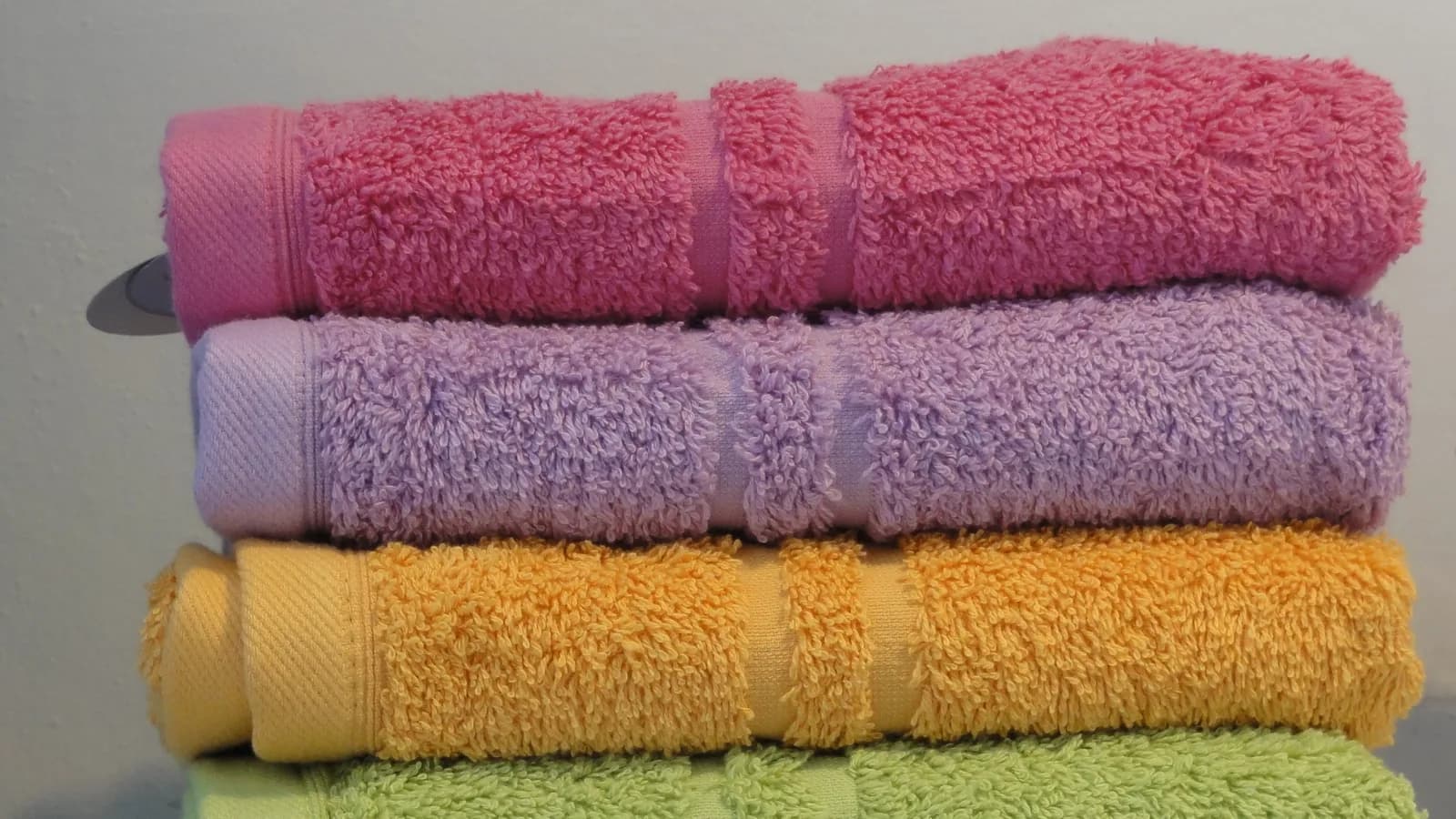 A stack of folded towels in several colours