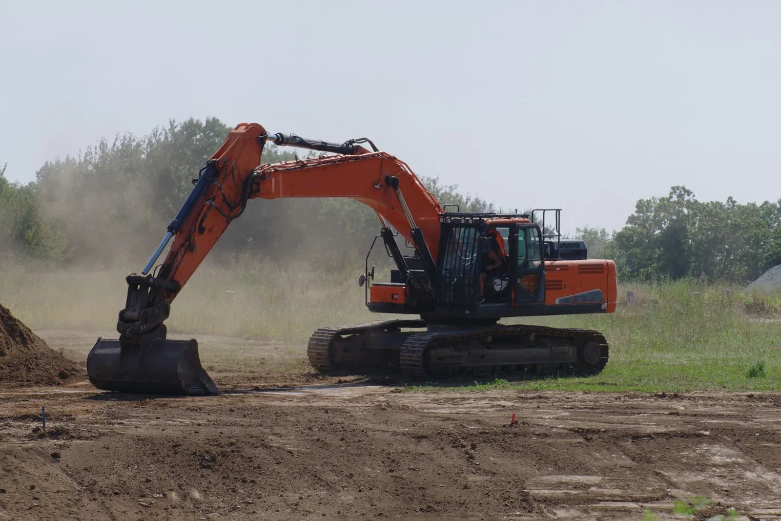 A row of rental excavators and skid steers lined up in an equipment rental yard