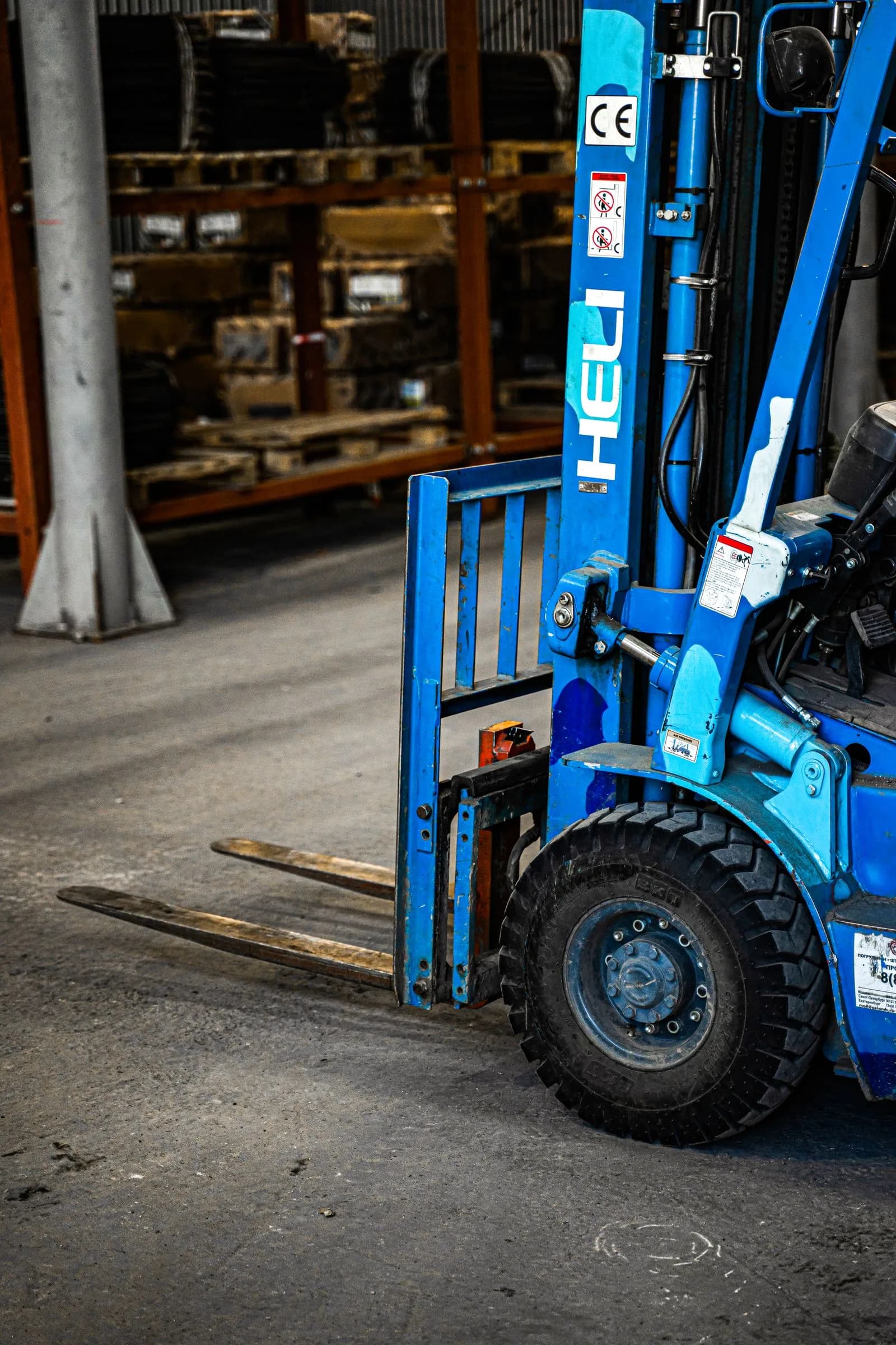 A forklift parked idle inside an industrial warehouse