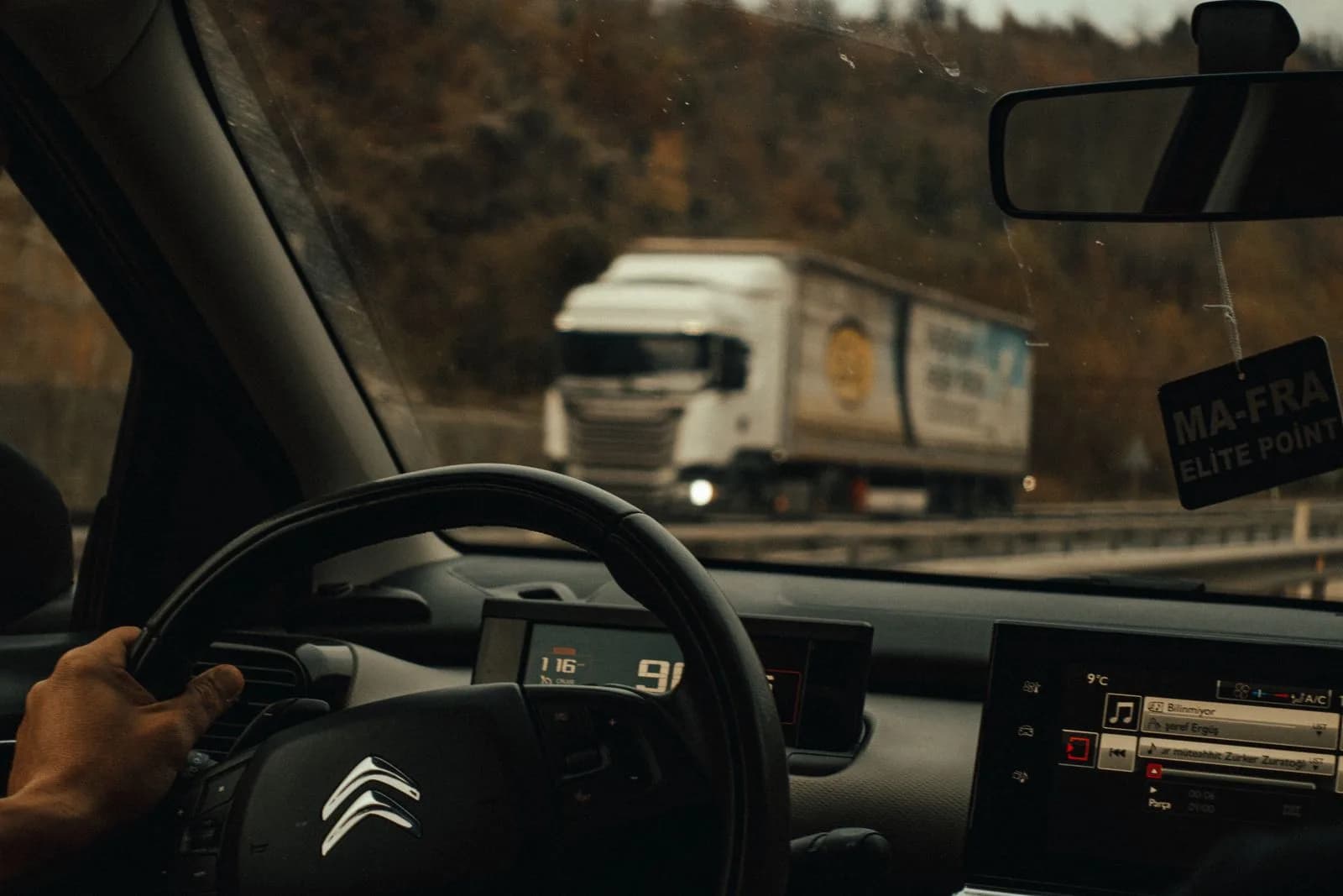 View from a vehicle's windshield showing a truck ahead on the highway