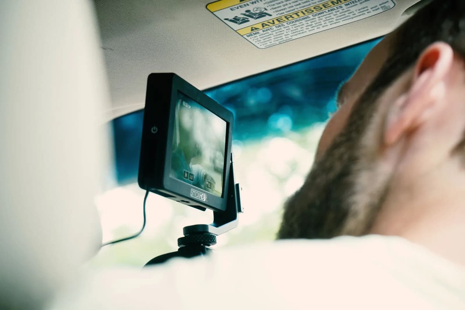 A driver using a dashboard camera mounted on the windshield