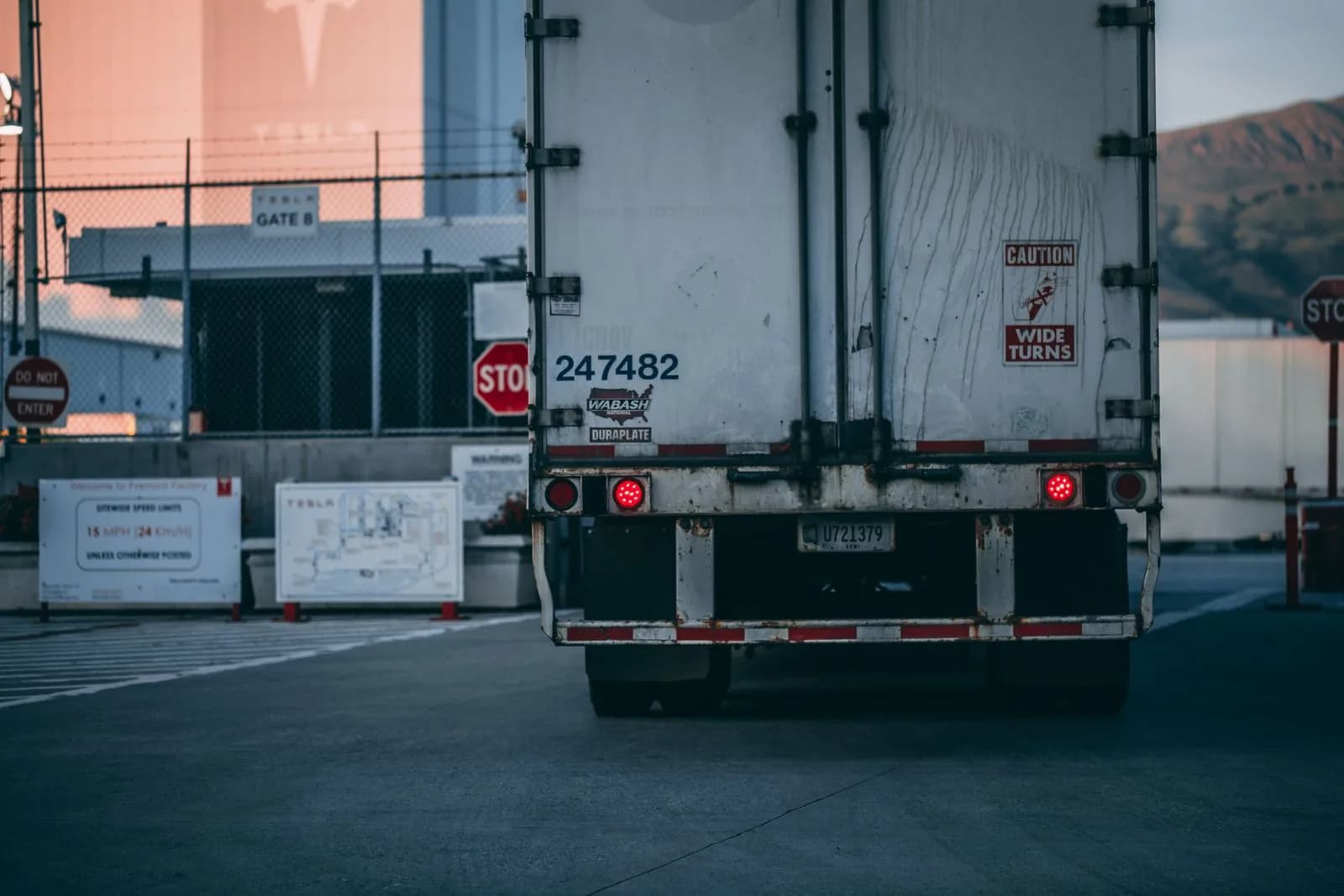 The rear of a commercial semi trailer at a yard gate