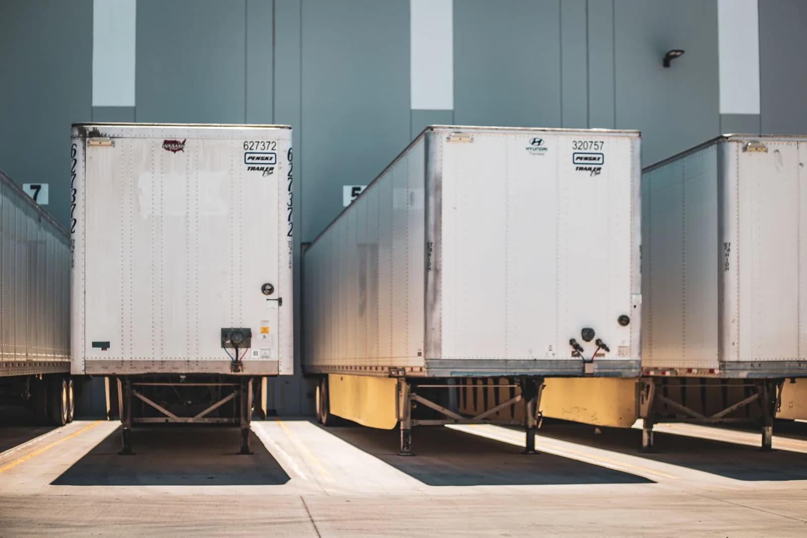 A row of refrigerated freight trailers parked at a commercial loading dock