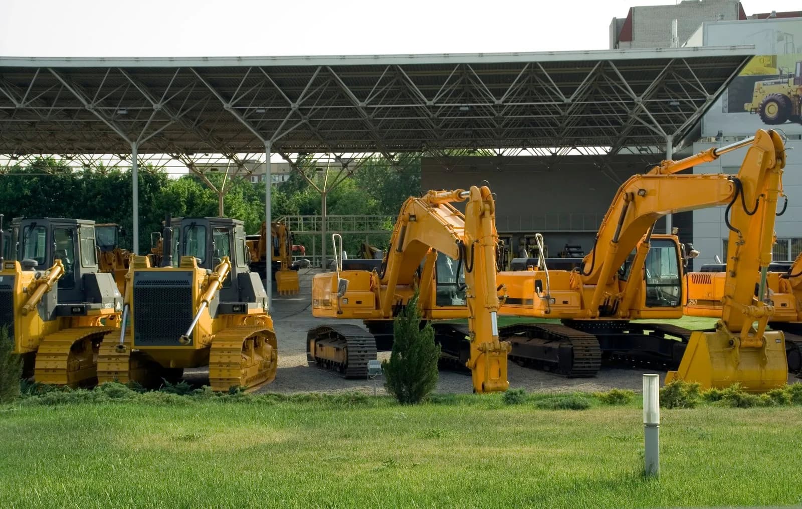 Heavy construction equipment including excavators and bulldozers parked in a yard
