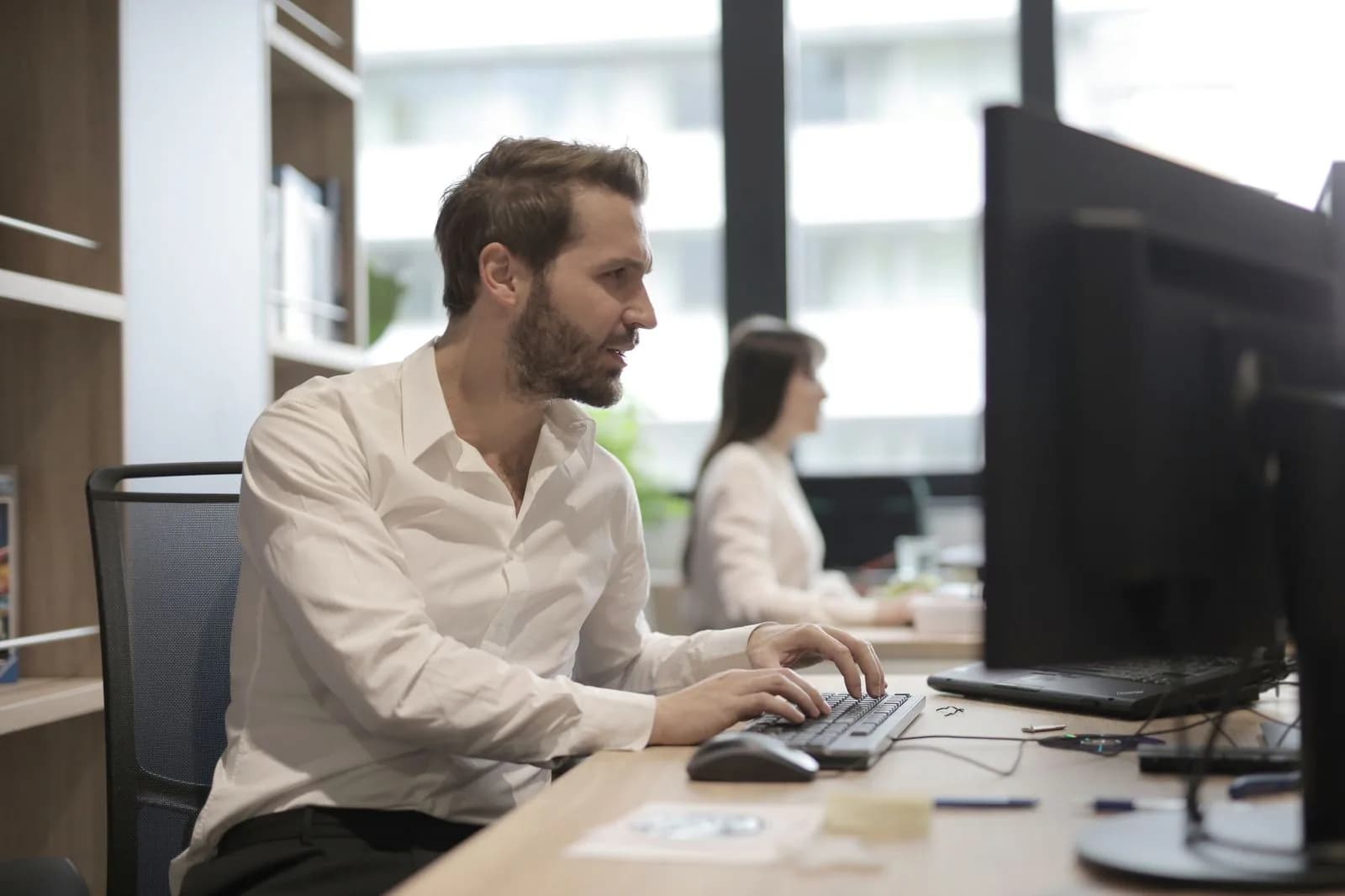 A person working on a computer at an office desk