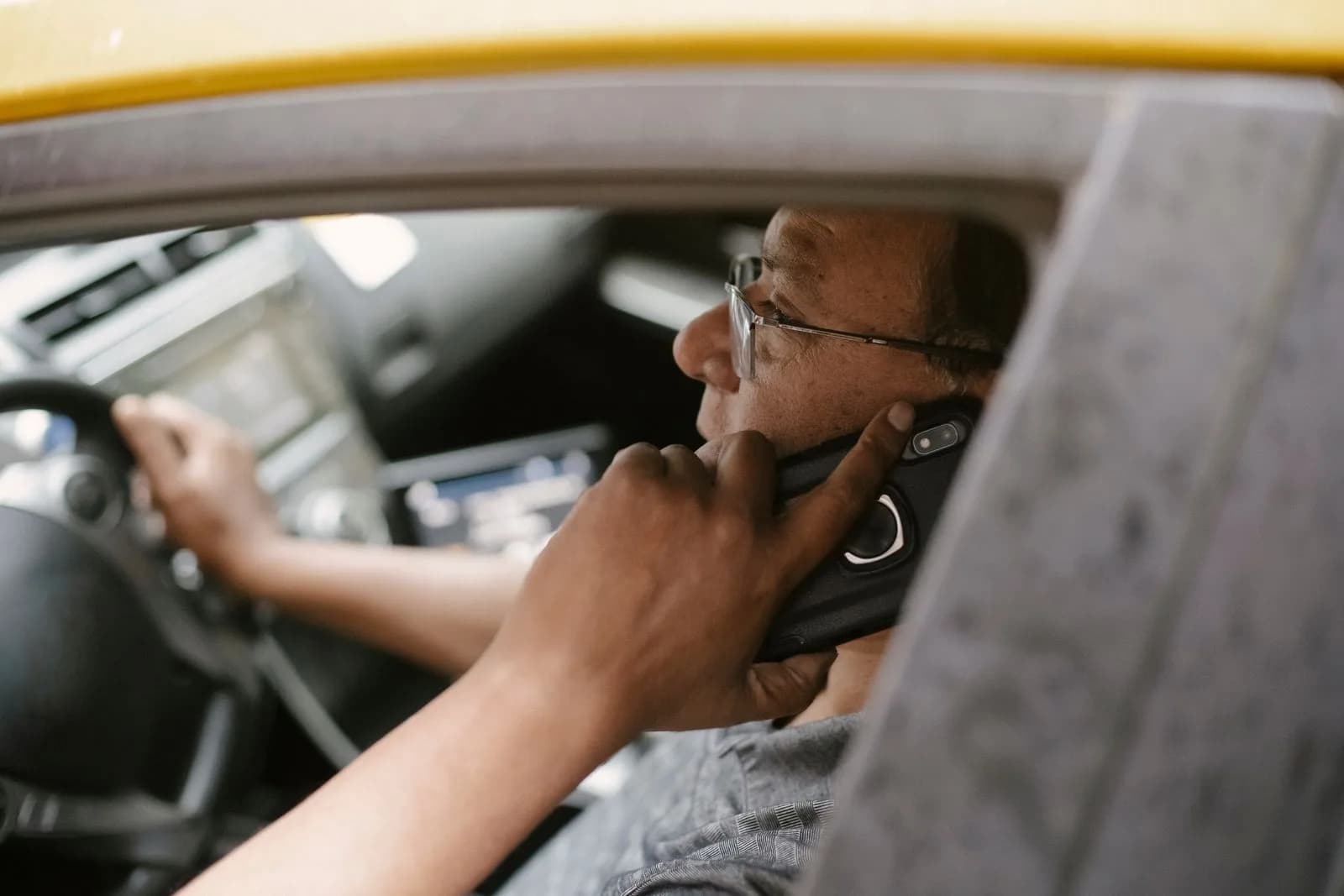 Un propriétaire-exploitant consultant des documents sur un téléphone intelligent dans la cabine d'un camion