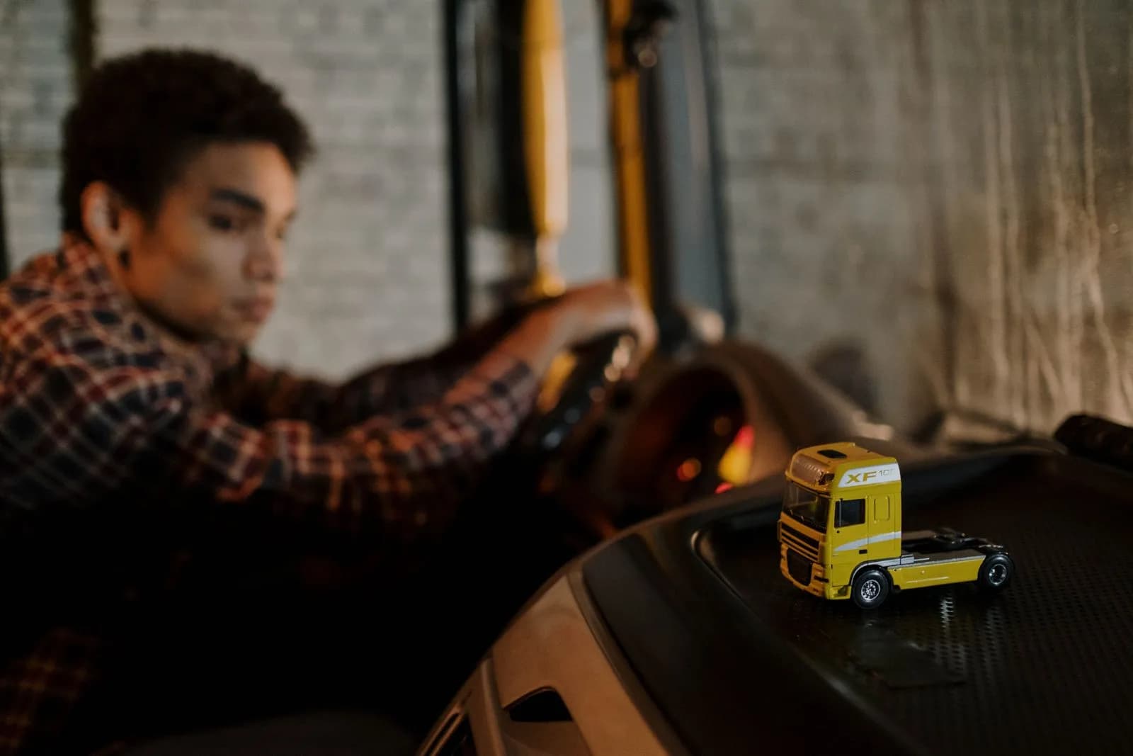 A commercial truck driver resting in the cab of a truck
