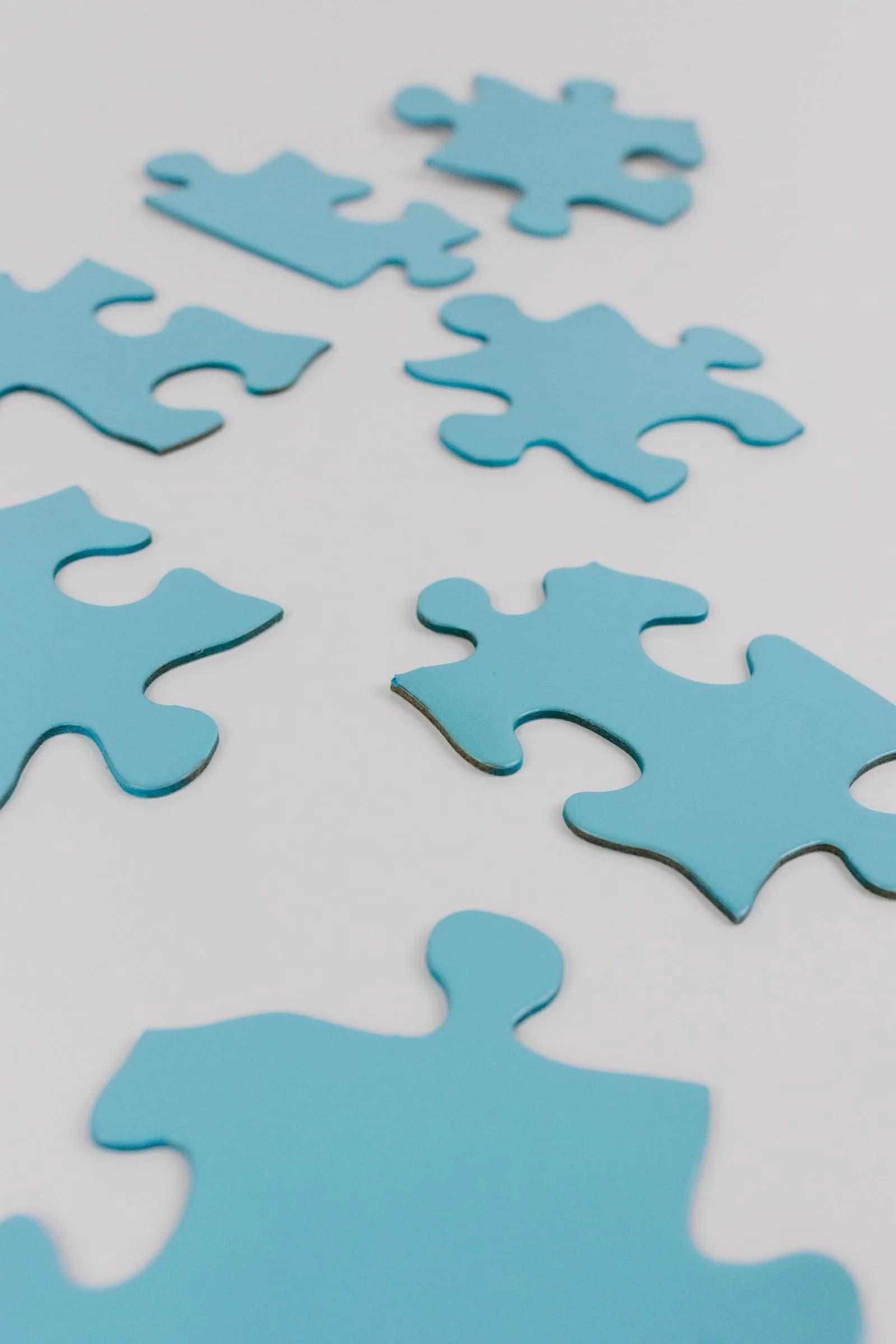 Des pièces de casse-tête bleues sur une surface blanche, représentant des intégrations qui s'emboîtent